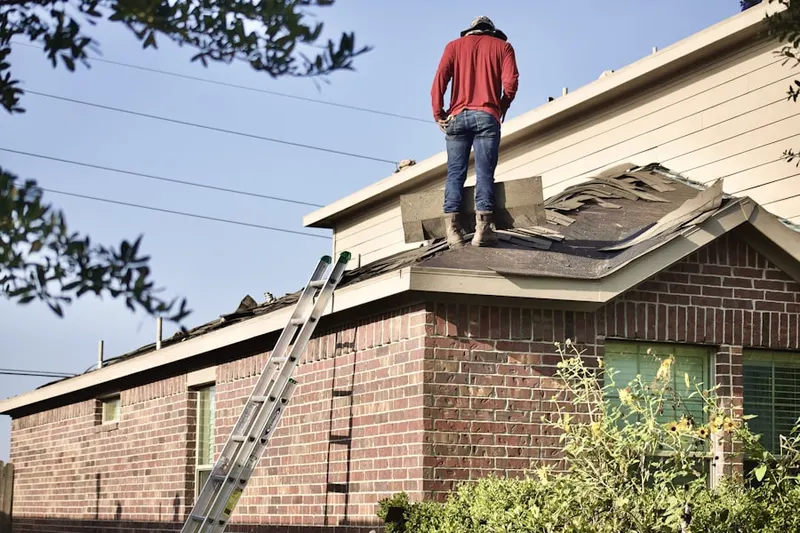 Professional roofer working on a residential roof in Pittsford